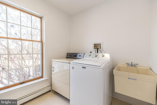 washroom with washer and dryer, a healthy amount of sunlight, sink, and a baseboard radiator