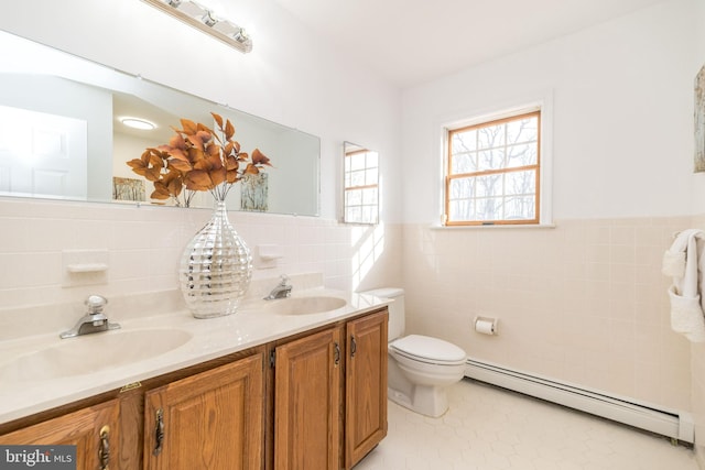 bathroom with vanity, a baseboard heating unit, tile walls, tile patterned flooring, and toilet