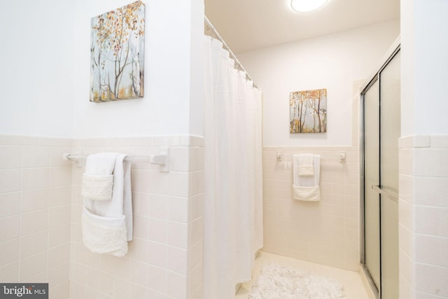 bathroom with tile walls and walk in shower