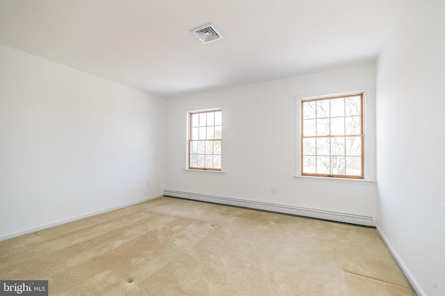 unfurnished room featuring baseboard heating and light carpet