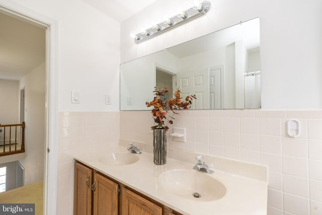 bathroom with vanity and tile walls