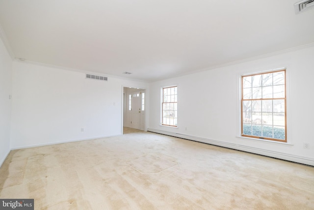 carpeted empty room with ornamental molding and a baseboard heating unit