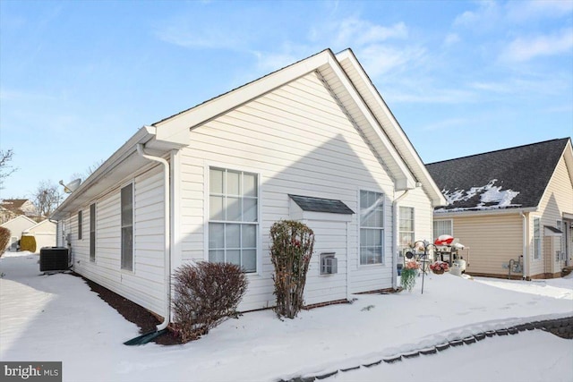 snow covered property with central AC