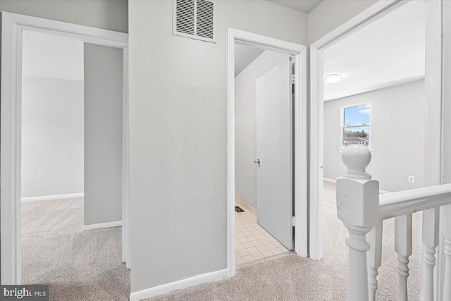 corridor featuring carpet flooring, baseboards, and visible vents