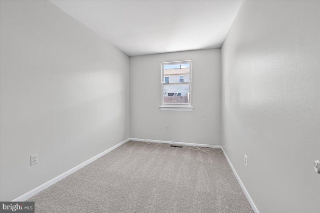 unfurnished room featuring carpet and baseboards