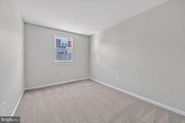 spare room with baseboards and carpet