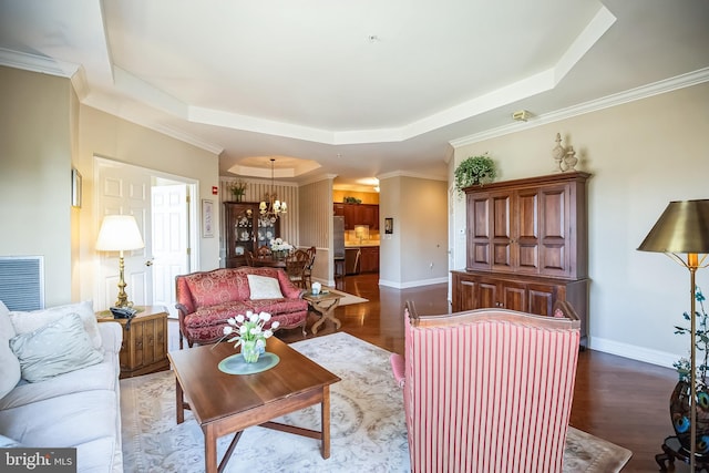 living room with dark hardwood / wood-style floors, a tray ceiling, and crown molding