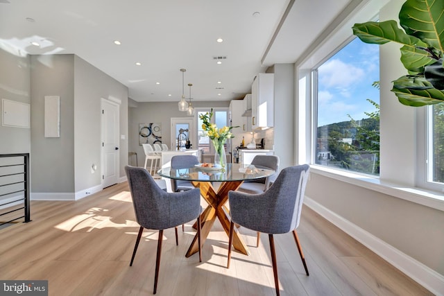 dining room with a wealth of natural light and light hardwood / wood-style floors