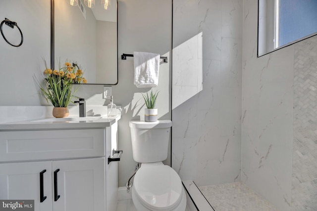 bathroom featuring vanity, toilet, and a tile shower