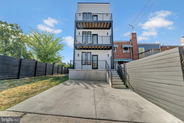 back of house with a yard and a balcony