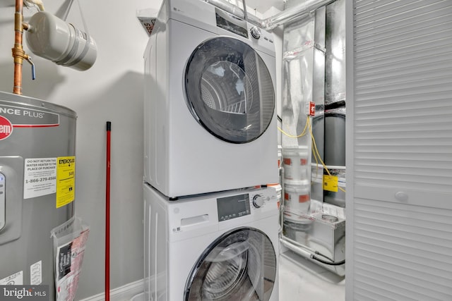 clothes washing area featuring stacked washer / drying machine and water heater