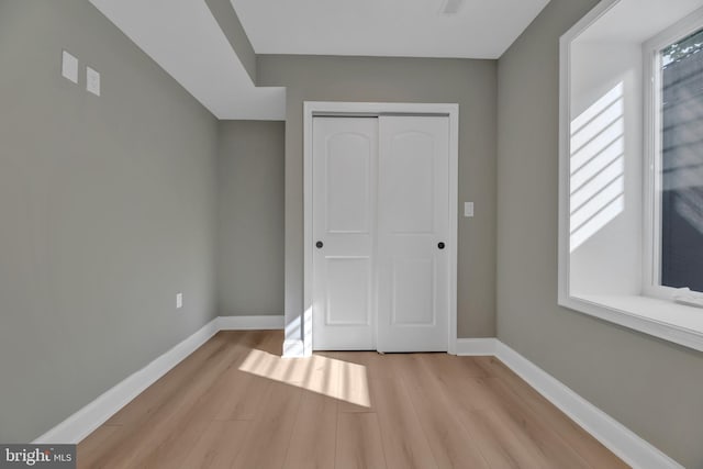 unfurnished bedroom featuring a closet and light hardwood / wood-style flooring