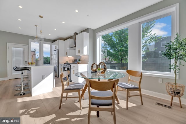 dining room with plenty of natural light and light wood-type flooring