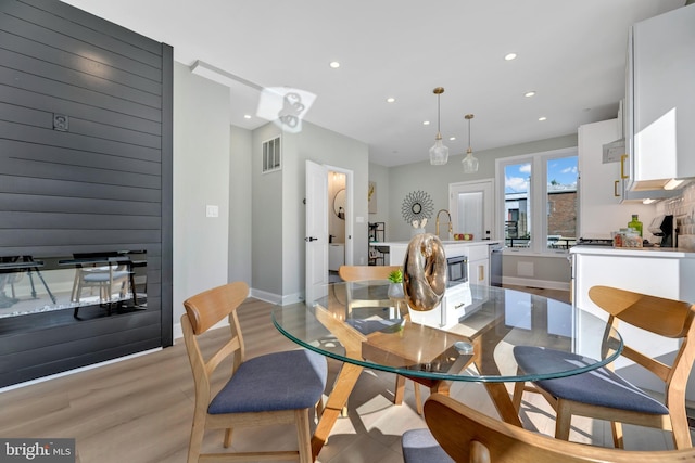 dining area featuring light wood-type flooring and sink