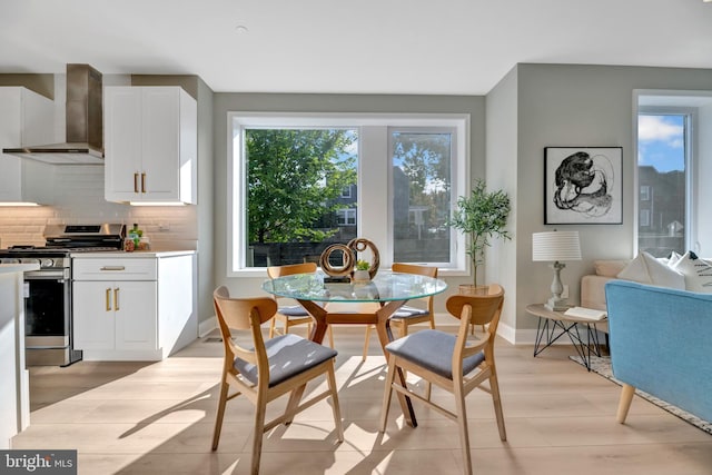 dining area with a healthy amount of sunlight and light hardwood / wood-style floors