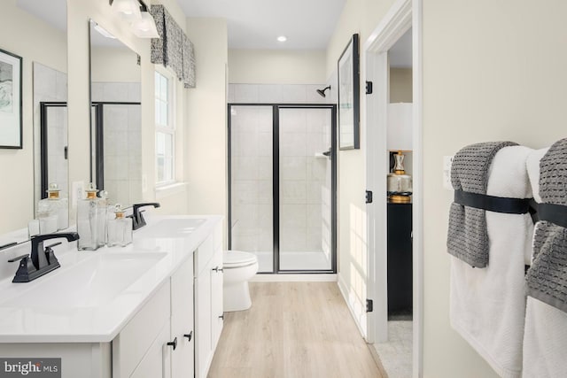 bathroom with vanity, wood-type flooring, toilet, and walk in shower