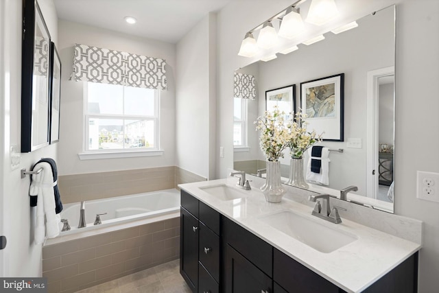 bathroom featuring vanity and tiled tub