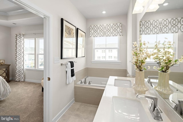 bathroom featuring tiled tub and vanity