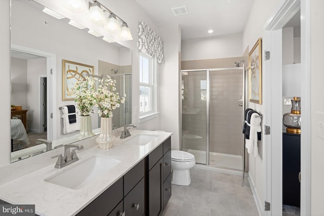 bathroom with vanity, toilet, a shower with shower door, and tile patterned flooring