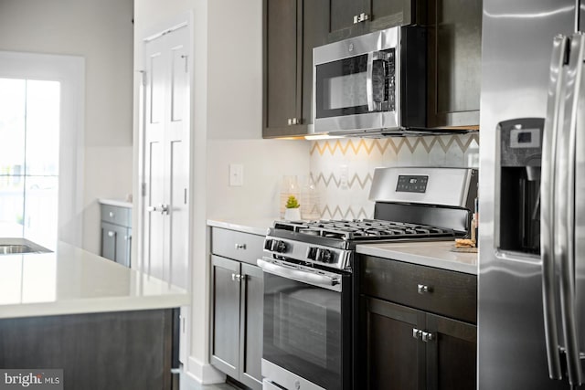 kitchen with backsplash, dark brown cabinets, and stainless steel appliances