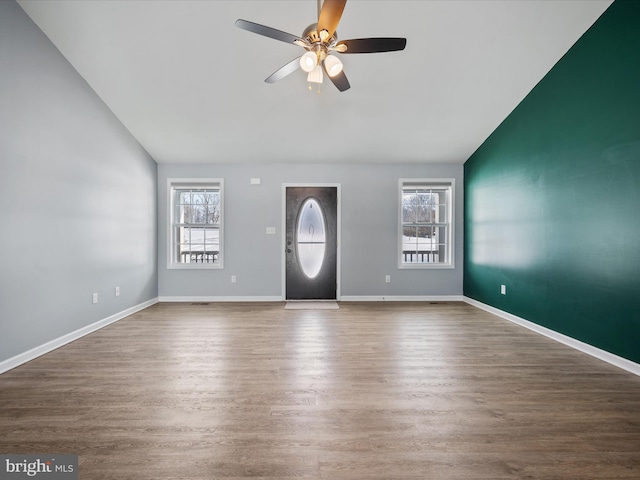 entrance foyer with lofted ceiling, ceiling fan, a wealth of natural light, and wood-type flooring