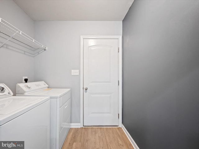 laundry area featuring independent washer and dryer and light hardwood / wood-style floors