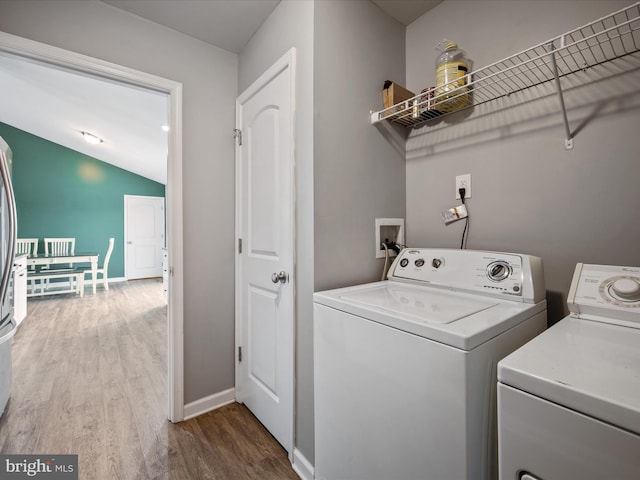 laundry room with wood-type flooring and separate washer and dryer