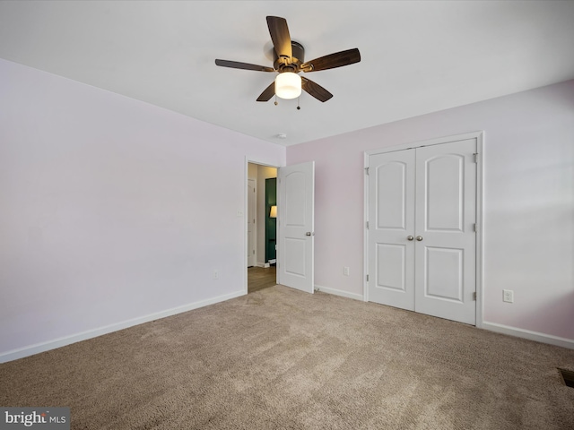 unfurnished bedroom with carpet floors, ceiling fan, and a closet