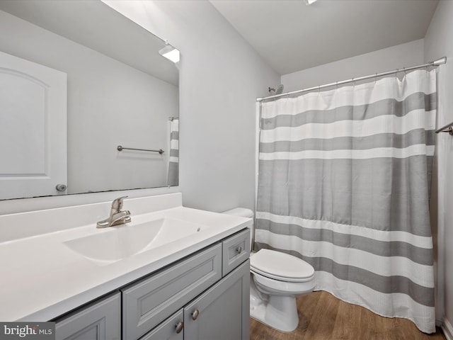 bathroom with vanity, hardwood / wood-style floors, curtained shower, and toilet