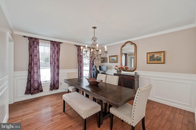 dining space with a chandelier, crown molding, and light hardwood / wood-style floors