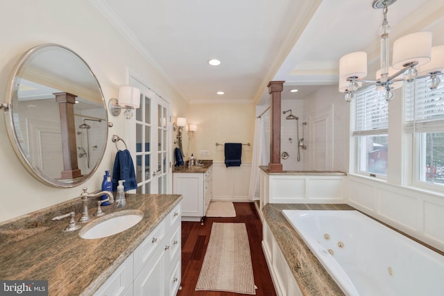 bathroom with plus walk in shower, crown molding, hardwood / wood-style flooring, and vanity