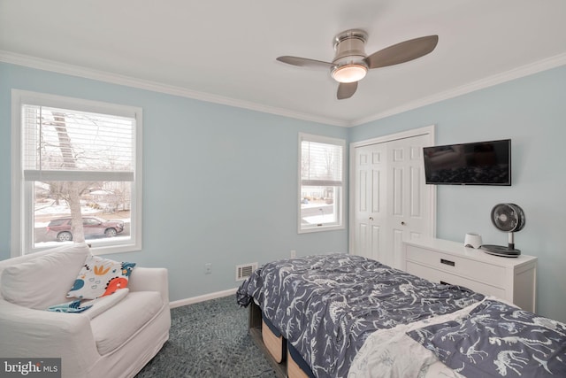 carpeted bedroom featuring ceiling fan, a closet, and ornamental molding