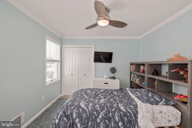 carpeted bedroom featuring ceiling fan, a closet, and crown molding