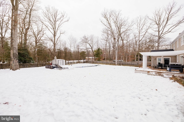 yard covered in snow featuring a storage shed