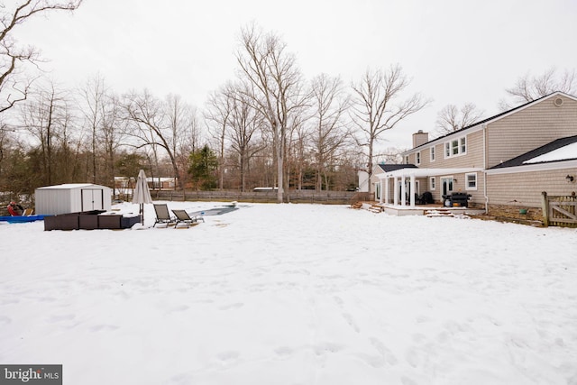 yard layered in snow with a shed