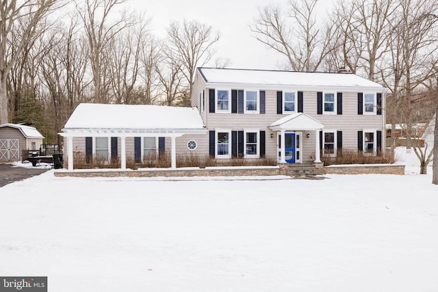 colonial house featuring a storage shed