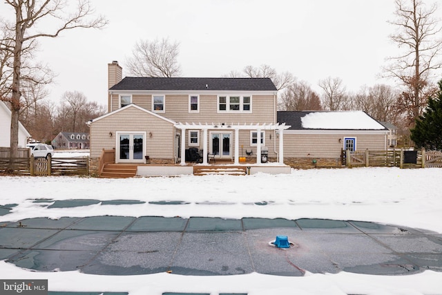 snow covered house featuring a pergola