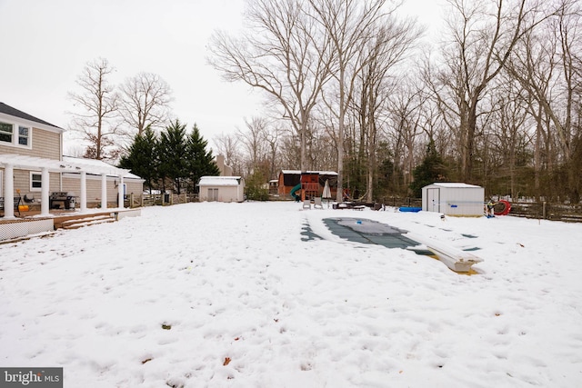 snowy yard featuring a shed