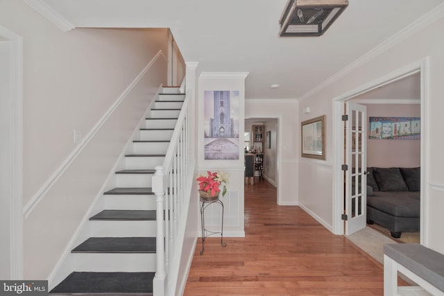 stairway featuring ornamental molding and hardwood / wood-style floors