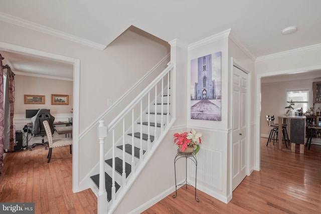 stairs featuring crown molding and hardwood / wood-style floors