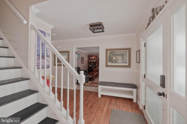 foyer with ornamental molding and light hardwood / wood-style floors