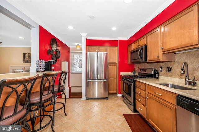 kitchen featuring brown cabinets, stainless steel appliances, and a sink