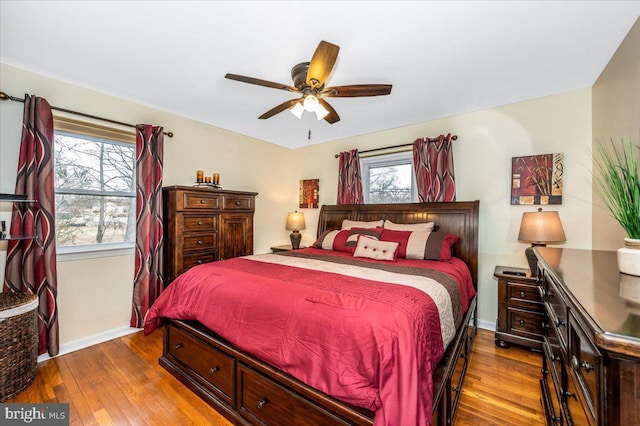 bedroom featuring a ceiling fan, baseboards, and wood finished floors