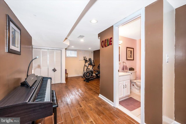 workout room with baseboards, visible vents, wood finished floors, and recessed lighting