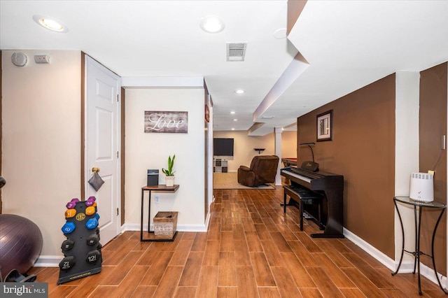 hallway with wood tiled floor, visible vents, baseboards, and recessed lighting