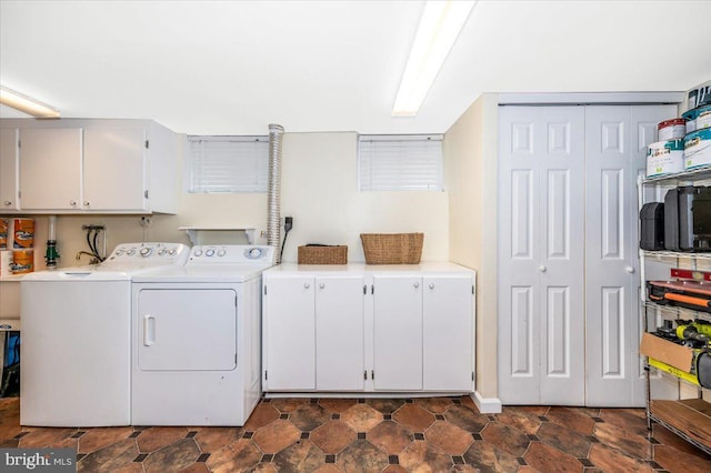 clothes washing area featuring washer and clothes dryer and cabinet space