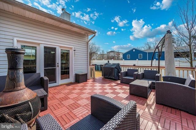 wooden deck featuring area for grilling, fence, and an outdoor living space