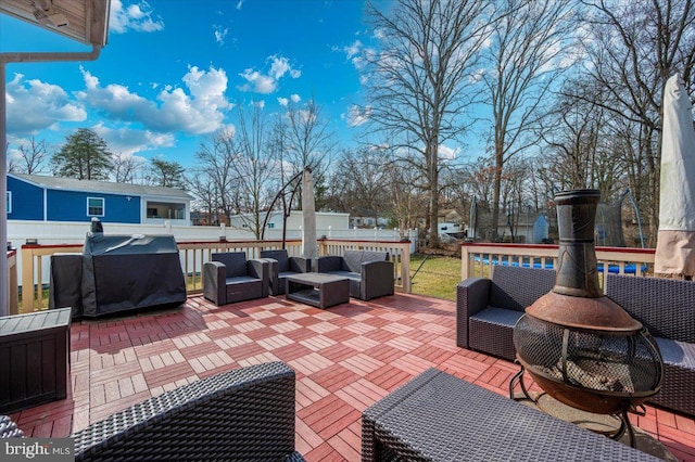 wooden terrace with a grill and an outdoor living space with a fire pit