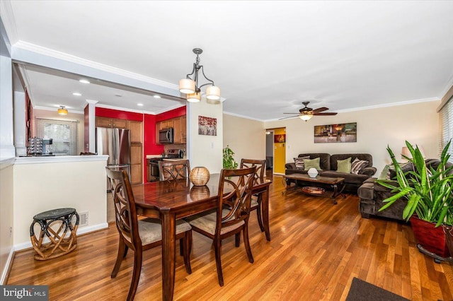 dining space with ornamental molding, wood finished floors, and ceiling fan with notable chandelier