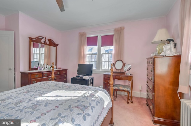 bedroom featuring light colored carpet, radiator, and ceiling fan